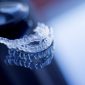 Clear dental aligners sitting on glass table