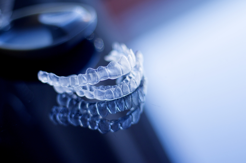 Clear dental aligners sitting on glass table