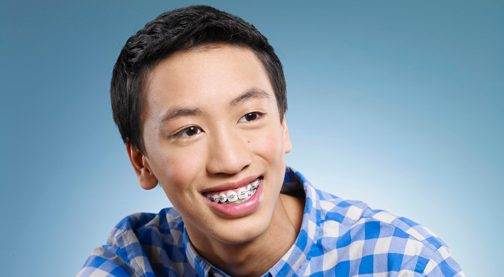 teen boy smiling with metal braces